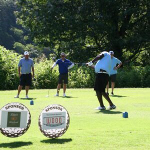 A group of men playing golf on the green.