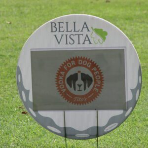 A sign is posted on the grass for people to see.