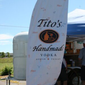 A man standing next to a tent with a sign.