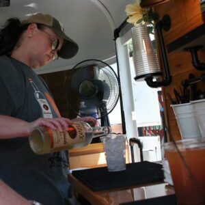 A woman is pouring coffee from the pot.