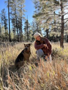 Paige and her dog sitting in the woods